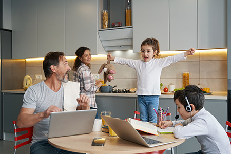 bilde av fornøyd familie rundt kjøkkenbordet med diverse dingser